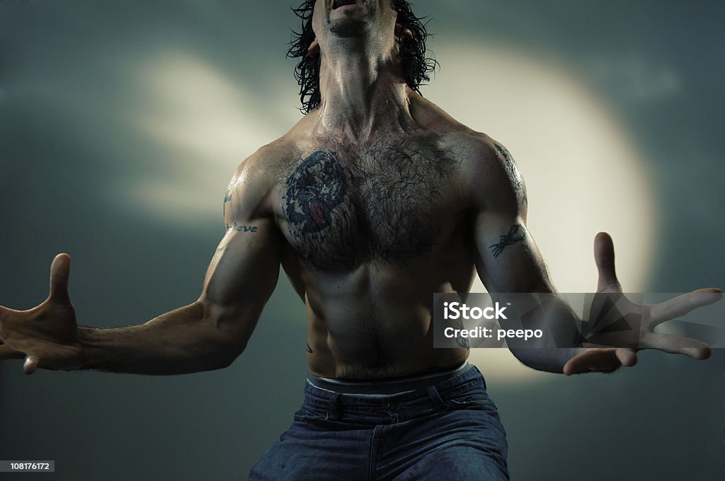Hombre sin camisa sosteniendo brazos en la espectacular de moda - Foto de stock de Sin camisa libre de derechos