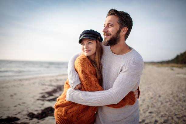 ビーチで歩く - attractive couple ストックフォトと画像