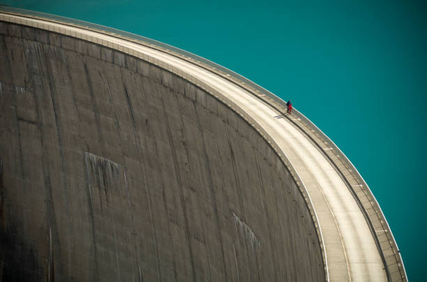Two People Looking Over the Edge of a Large Dam stock photo