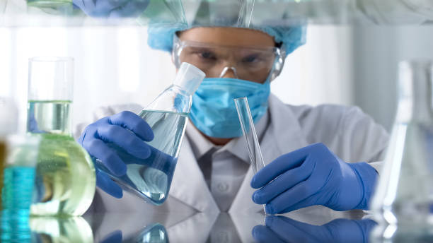 istock Male chemist in protective suit conducting experiment with toxic reagents 1081762510