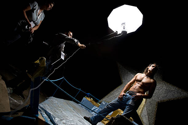 istock Photographer Shooting Scene with Lights, Assistants and Model 108176282