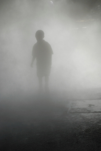 A boy walking through the mist