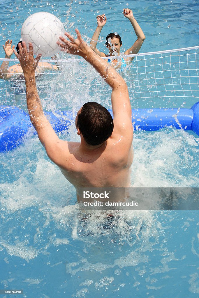 Gruppo di giovani giocare a pallavolo in piscina - Foto stock royalty-free di Pallavolo