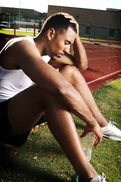 istock Defeated Runner Sitting on Edge of Track 108176507