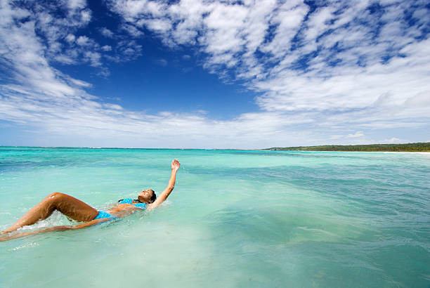 istock Young Woman Swimming Backwards in Tropical Ocean 108176542