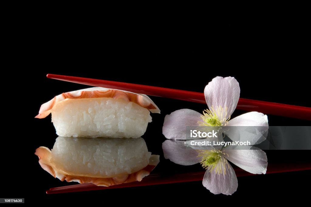 Sushi mit Blume und Stäbchen gegen schwarzem Hintergrund - Lizenzfrei Sushi Stock-Foto