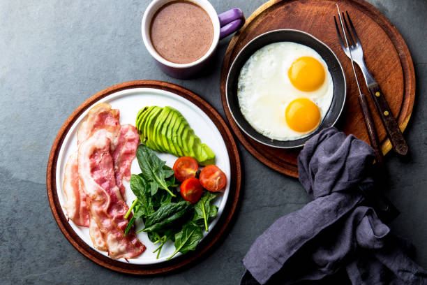 Ketogenic diet breakfast. fried egg, bacon and avocado, spinach and bulletproof coffee. Low carb high fat breakfast Ketogenic diet breakfast. fried egg, bacon and avocado, spinach and bulletproof coffee. Low carb high fat breakfast. ketogenic diet photos stock pictures, royalty-free photos & images