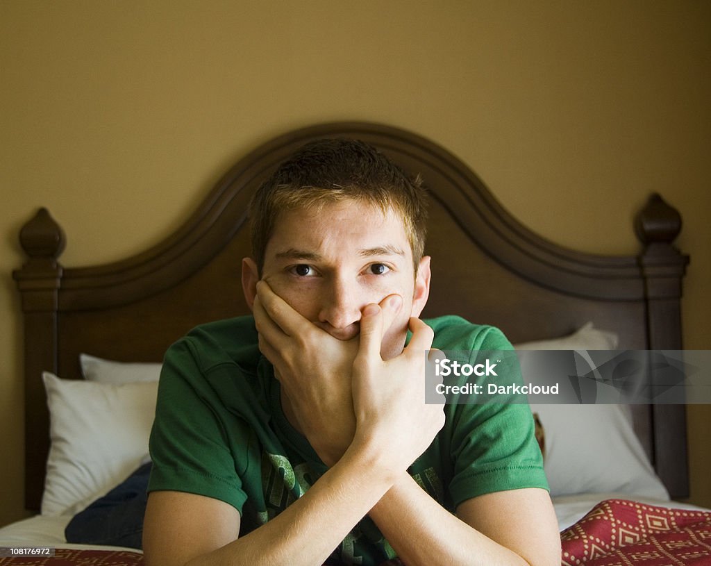 Teen на кровати с руками над рот - Стоковые фото В помещении роялти-фри