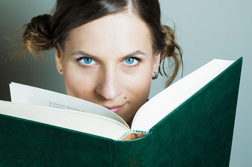 Girl holding books on the head. Concept of wisdom, knowledge and self-education . High quality photo