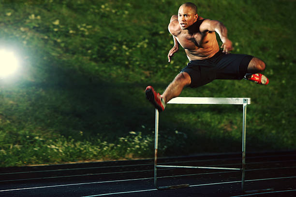 istock Male Athlete Jumping Hurdles at Night 108177053
