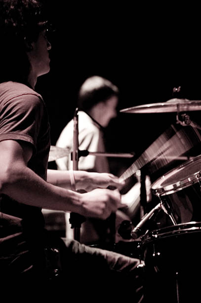 istock Man Playing Drums on Stage With Bassist in Background, Toned 108177230