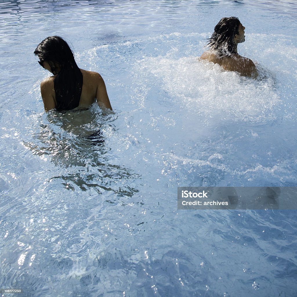 Junge Frau und Mann, die Spaß im Pool - Lizenzfrei Modisch Stock-Foto