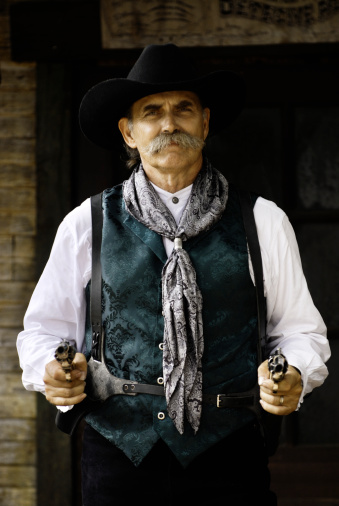 Portrait of a cowboy with his guns drawn.