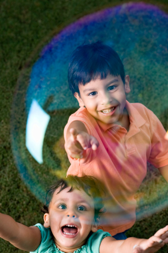 Girl and boy popping bubbles.