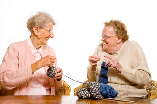 two happy senior woman with knitting needles