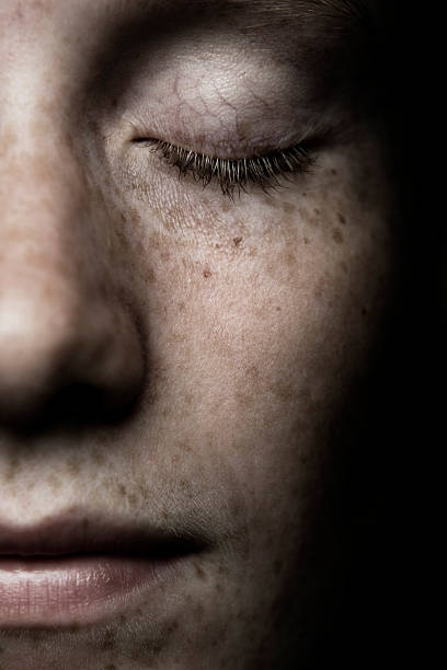 close-up of woman's freckled face - closing eyes men stockfoto's en -beelden