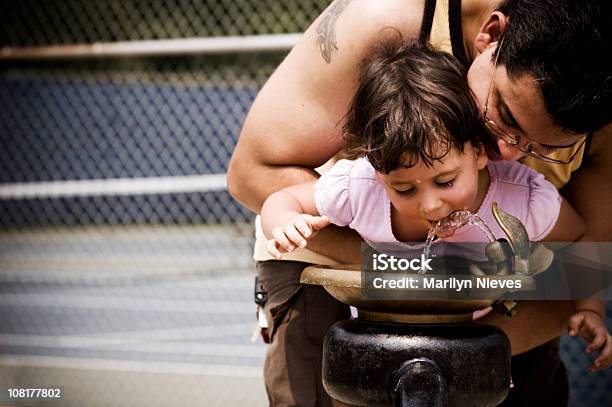 Padre Con Figlia Fino Alla Fontana - Fotografie stock e altre immagini di 2-3 anni - 2-3 anni, Abbigliamento casual, Acqua