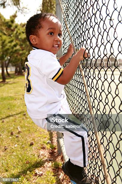 Rapaz Em Uniforme De Beisebol Escalada Vedação - Fotografias de stock e mais imagens de Afro-americano - Afro-americano, Amarelo, Ao Ar Livre