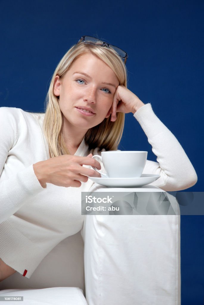 Jeune femme de détente sur le canapé avec une tasse de thé - Photo de Adulte libre de droits