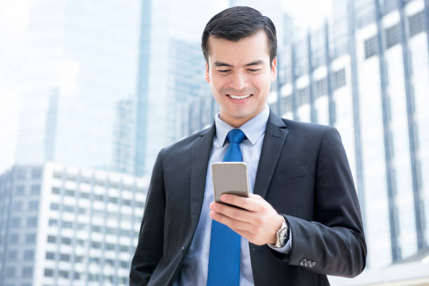 istock Businessman using smartphone in front of office buildings 1081783294