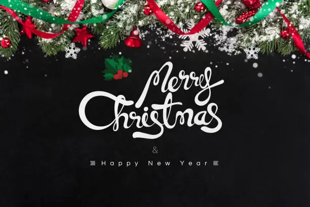 Merry Christmas and Happy New Year text with decorative ornaments on blackboard background