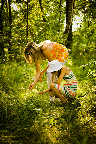 istock Mother and Daughter Picking Flowers in Forest 108178484