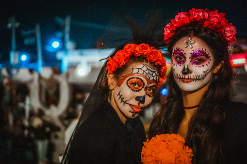 Portrait of a mother and daughter with traditional make up for Dia de los Muertos, Mexico