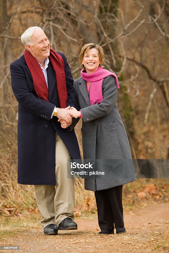 Senior Pareja caminando y sosteniendo las manos - Foto de stock de 50-54 años libre de derechos