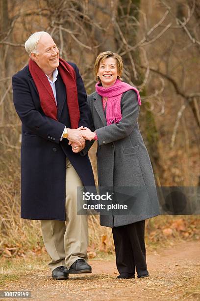 Senior Pareja Caminando Y Sosteniendo Las Manos Foto de stock y más banco de imágenes de 50-54 años - 50-54 años, 60-64 años, Abrazar