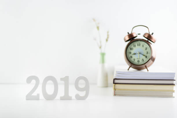 istock 2019 happy new year theme, professional designer office concept : Business work space / modern workplace and decor supplies place on desk table e.g number 2019 white wood cut, timer clock, books, vase 1081792540