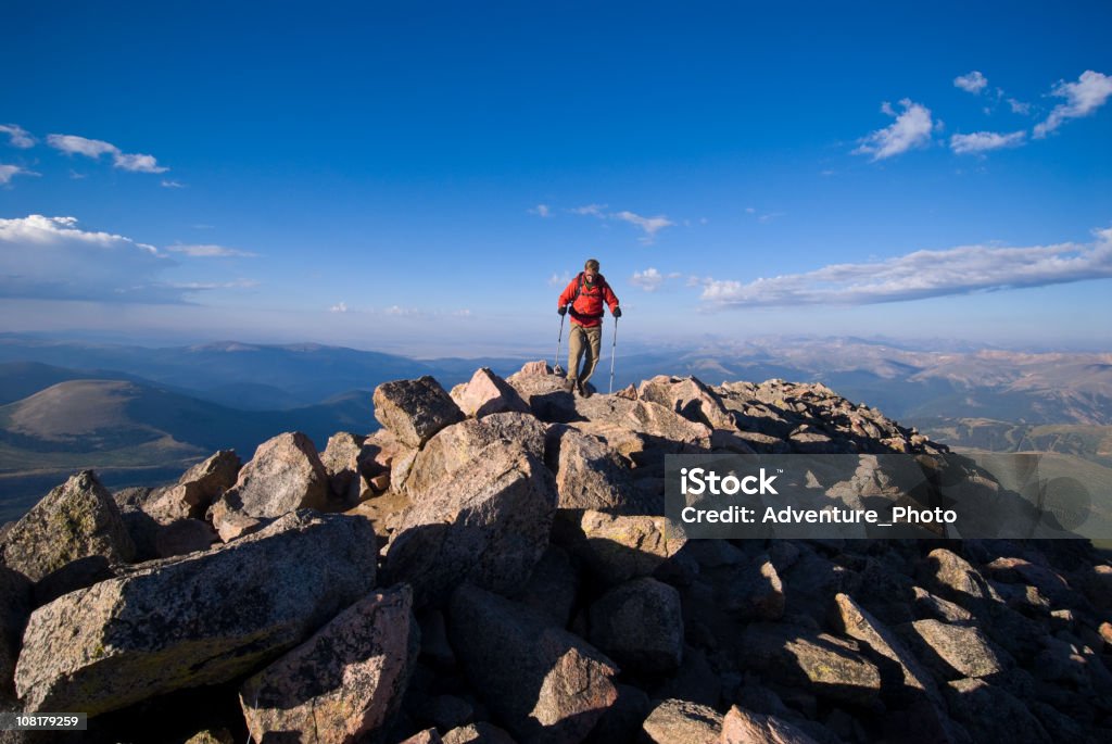 Uomo sulla cima di montagna escursioni in cima alle montagne rocciose - Foto stock royalty-free di Adulto