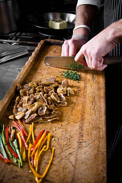 istock Chef Cutting Herbs on Wooden Chopping Board in Restaurant Kitchen 108179298
