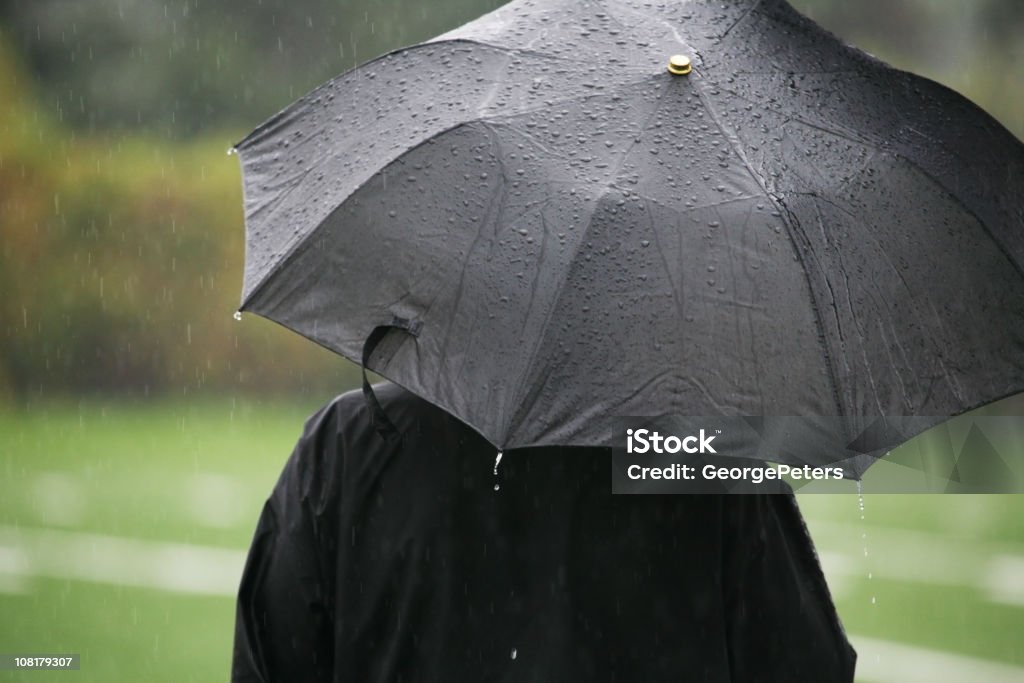 Personnes debout sous la pluie avec parapluie noir - Photo de Pluie libre de droits