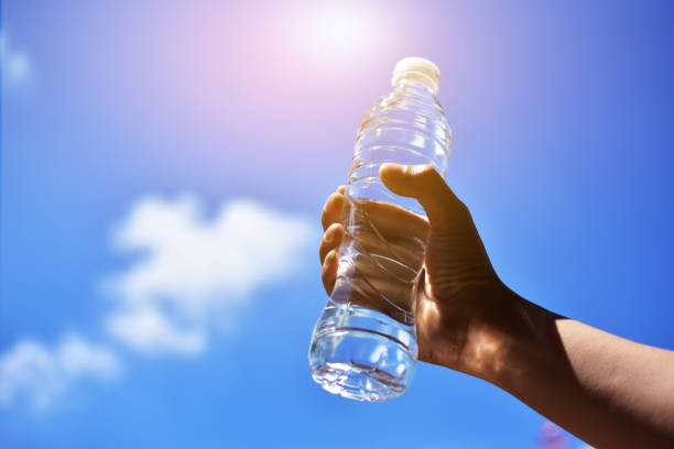 istock Hand holding water drink sky background 1081794470