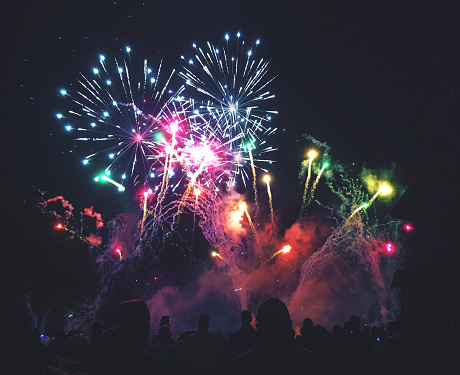 Crowd of People Watching a Colorful Fireworks Display for New Years or Fourth of July Celebration Event