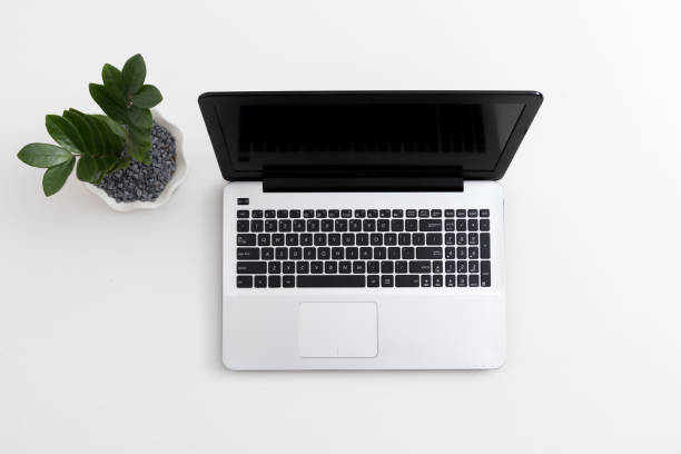 istock White office desk with laptop office plant and notebook 1081796772