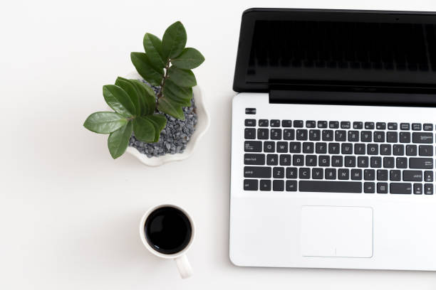 istock White office desk with laptop office plant and notebook 1081805348