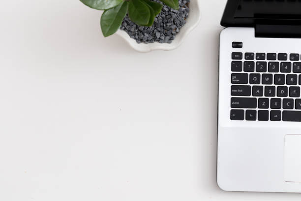 istock White office desk with laptop office plant and notebook 1081805926