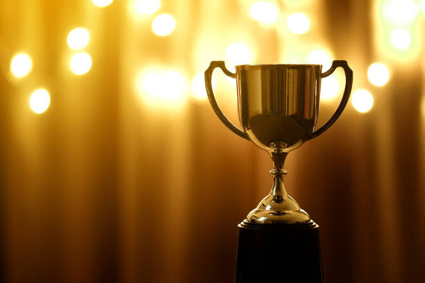 istock Gold Trophy competition in the dark on the abstract blurred light background with copy space, Spectacular success Concept 1081820706