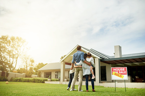 Shot of a family of four viewing their new home together