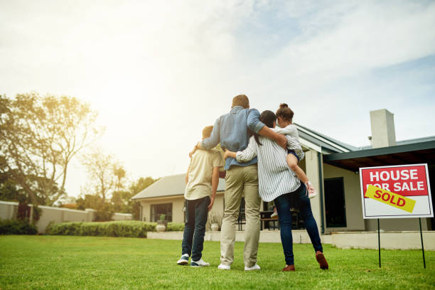 I'm moving my family into our dream home Shot of a family of four viewing their new home together suburb photos stock pictures, royalty-free photos & images