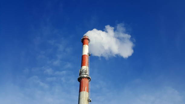 istock High industrial chimney with white smoke on blue sky background 1081834826