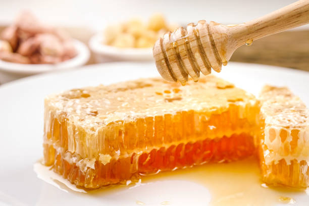istock honeycomb dipper and honey on white background 1081842062