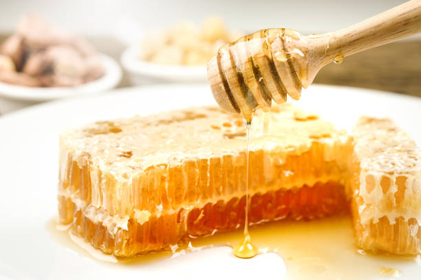 istock honeycomb dipper and honey on white background 1081842084