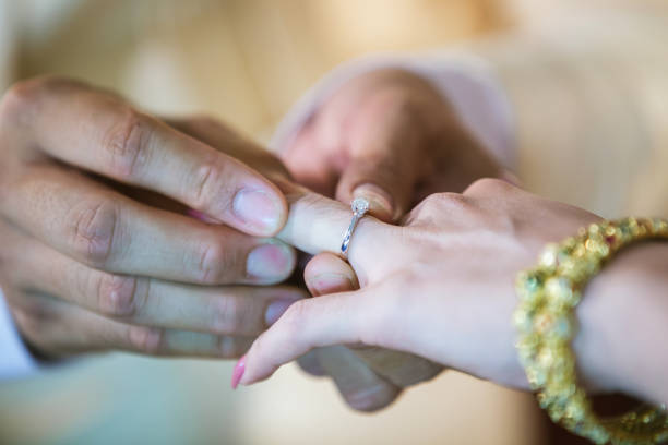 istock Wedding rings. He Put the Wedding Ring on Her. Close up Groom Put the Ring on bride. 1081856878