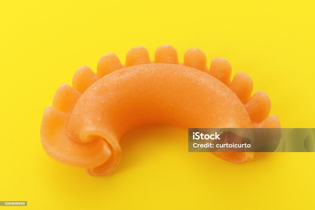 Italian pasta Pasta creste di gallo on yellow background Carbohydrate - Food Type Stock Photo