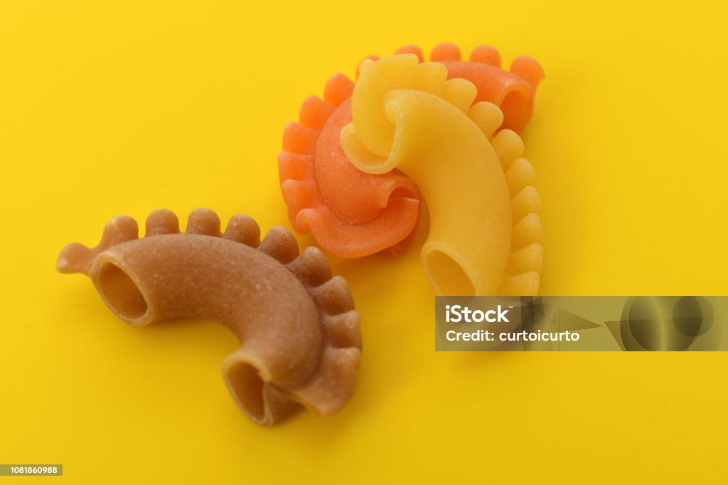 Italian pasta Pasta creste di gallo on yellow background Carbohydrate - Food Type Stock Photo
