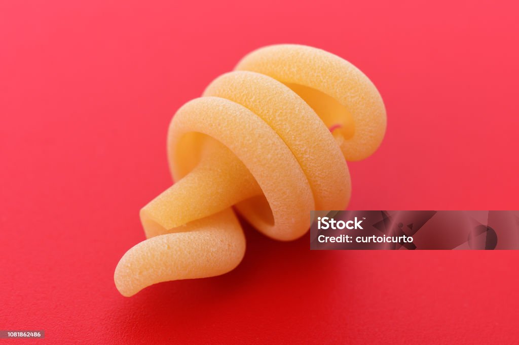 Italian pasta trottole  with red background Carbohydrate - Food Type Stock Photo