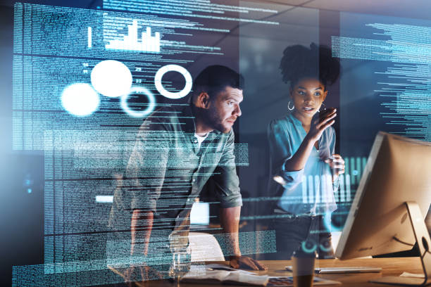 Keeping up with modern advancements Shot of two programmers working together on a computer code at night digital code stock pictures, royalty-free photos & images