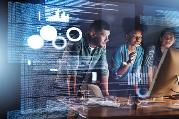 We'll crack through this code tonight Shot of a group of programmers working together on a computer code at night digital code stock pictures, royalty-free photos & images
